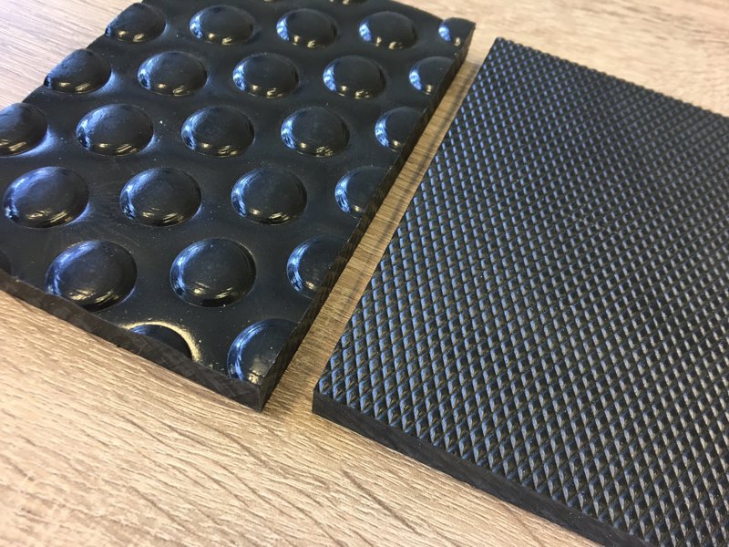 Zwei schwarze Ekogrip-Platten von Ekon, eine mit Noppenstruktur und eine mit Diamantstruktur